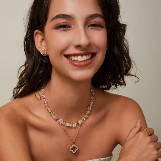 Woman wearing a necklace and bracelet with a neutral background